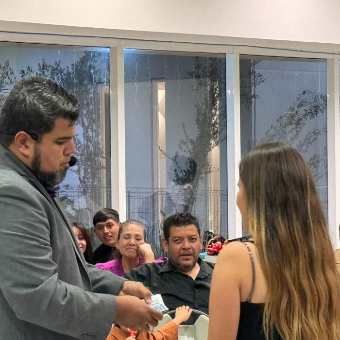 El mago Eduardo Aviña realiza un truco de cartas con un voluntario del publico interactuando de manera directa con una chica de su publico en su evento realizado en Guadalajara, Jalisco, México.